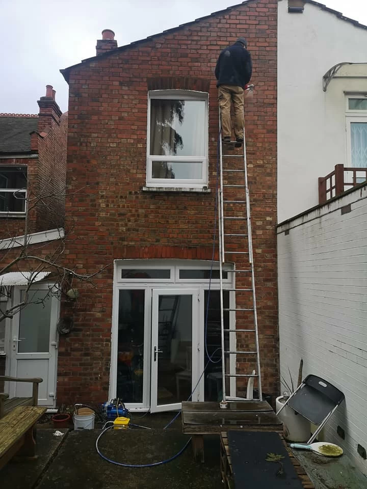 Advanced damp on high ladder using spray injection to treat penetrating damp wall