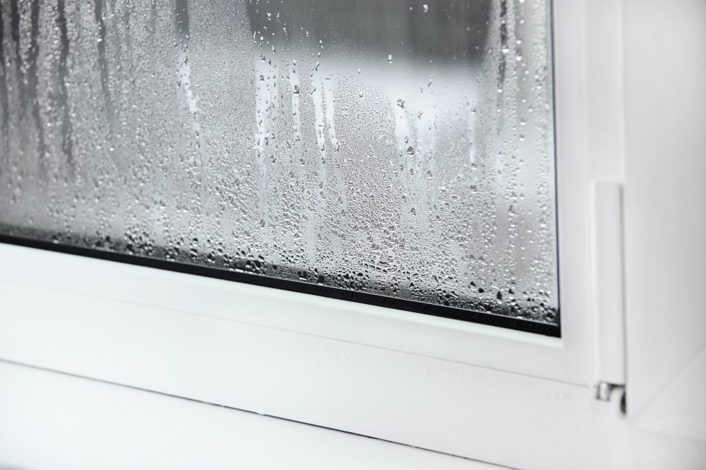 a plastic window with condensation of water on the glass. Double glazed PVC window. Concept: