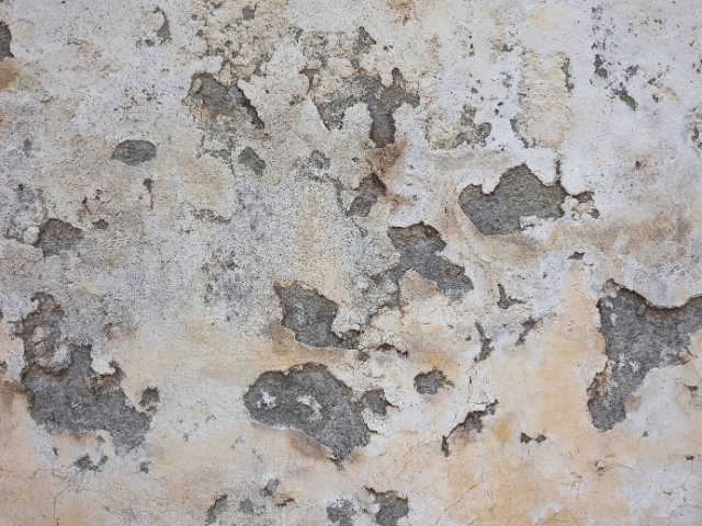 Dark stains and peeling of paintwork on a wall