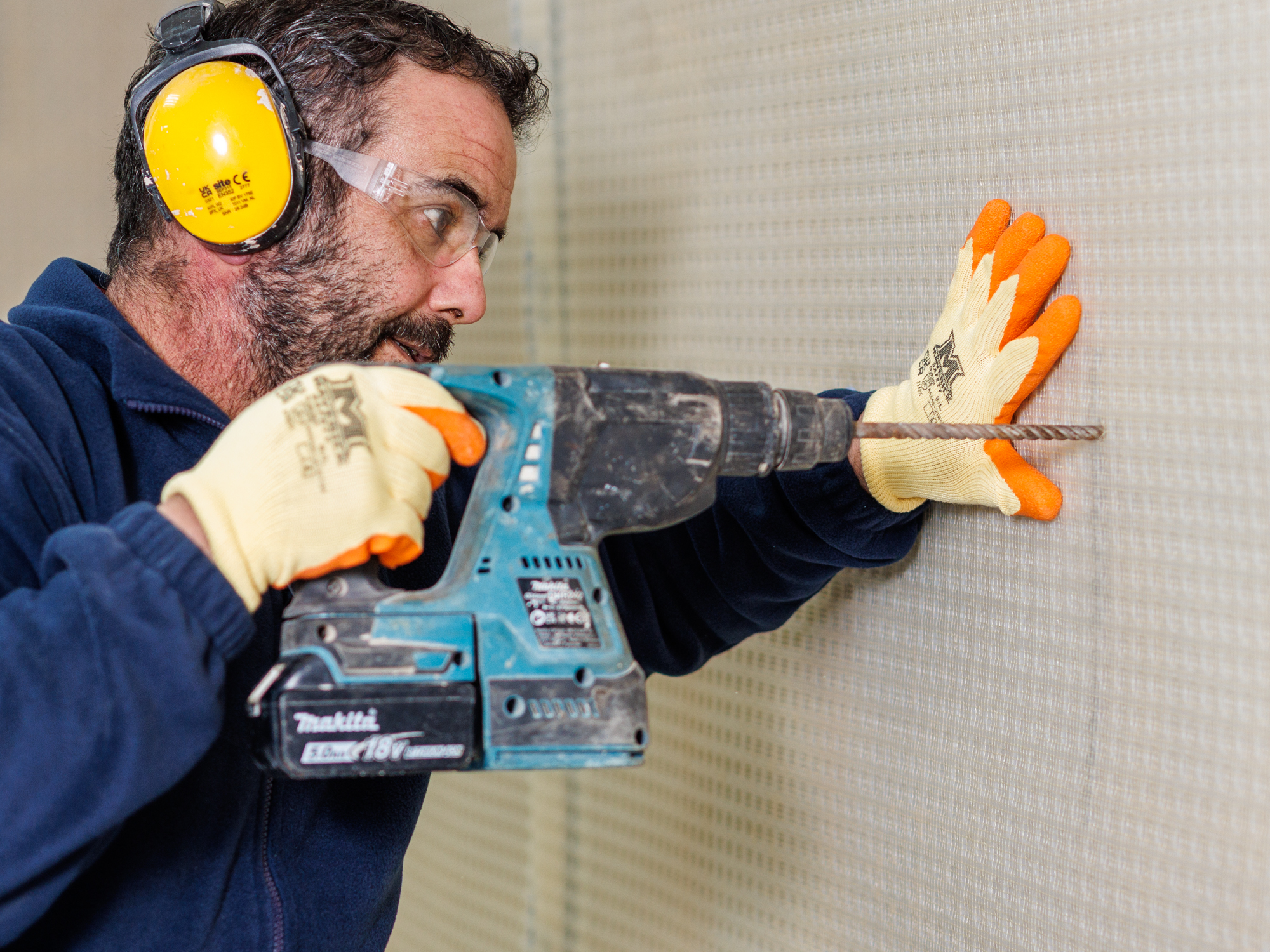 Advanced Damp technician installing cavity drain membrane at a Hackney E8 property